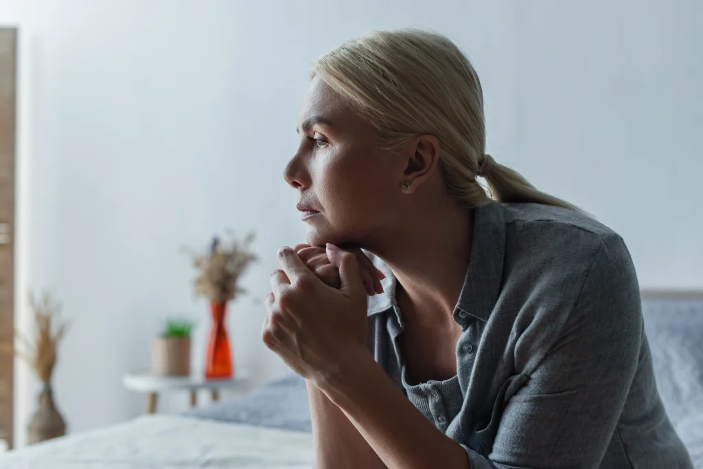 lady sat with chin on hands looking worried